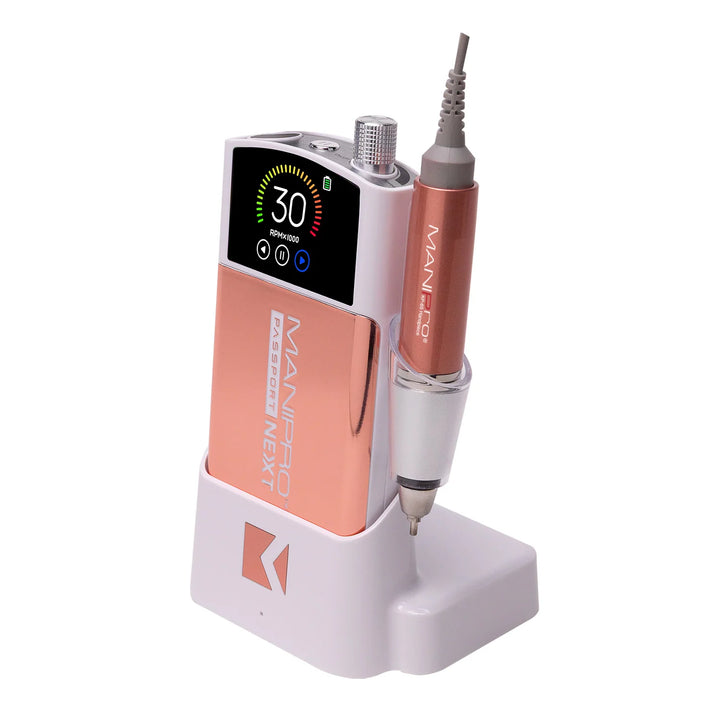 KUPA MANIPro Passport NEXT nail drill in Rose Gold, angled side view in white charging dock with handpiece